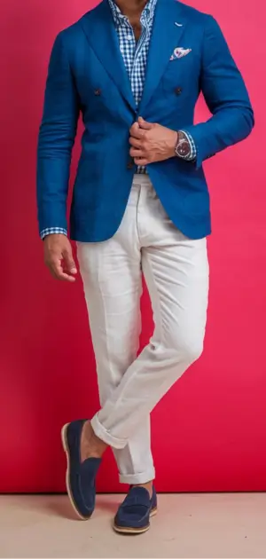 Man in a blue blazer, white pants, and loafers showcasing casual formal attire.