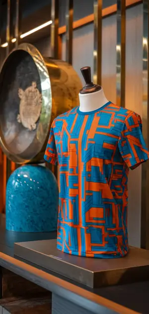 Blue and orange abstract pattern T-shirt on display