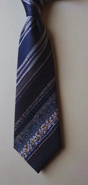 A man styling a minimalist knit tie with a casual blazer and denim jeans.