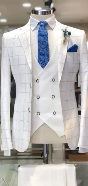 White formal checkered suit with a blue paisley tie and matching pocket square.