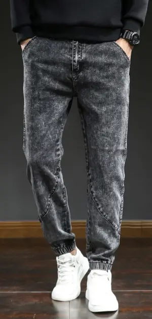 Grey-washed men’s jeans with a relaxed fit and ankle cuff details.