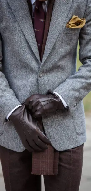Gray suit with maroon tie, brown gloves, and gold pocket square.