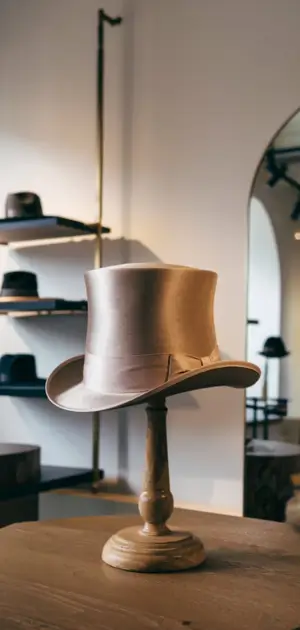 Men's luxury hat displayed on a pedestal.