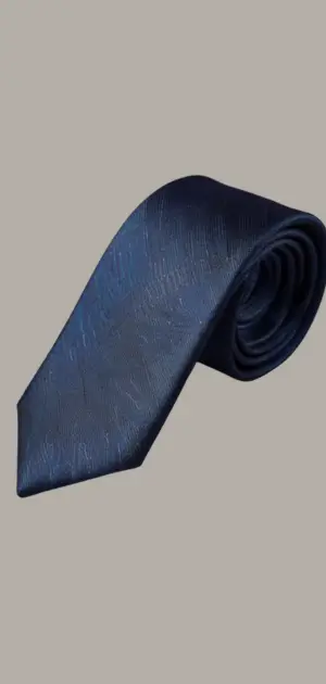 Skinny linen ties in muted tones displayed on a wooden table.