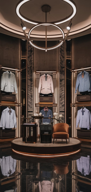 Mannequins presenting pastel and neutral-colored dress shirts in a refined boutique