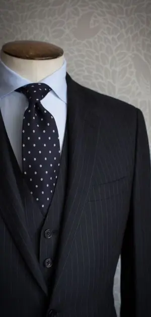 Black formal dress suits Black pinstriped suit with a blue shirt and polka-dot tie for a formal look.