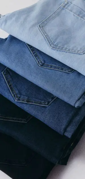 Men's slim bootcut jeans Four pairs of men’s bootcut jeans stacked in light to dark denim colors.