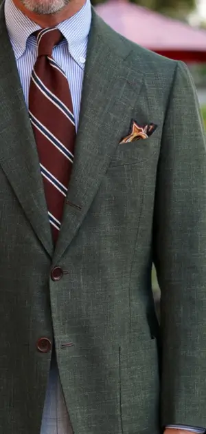 Green formal linen suits for men paired with a striped tie and decorative pocket square.