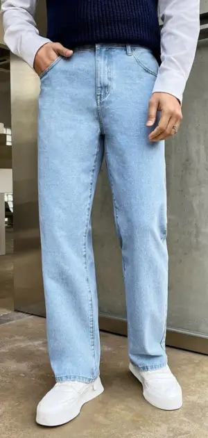Straight-leg light blue men's minimalist jeans styled with white sneakers and a modern outfit.