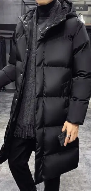 A stylish black polyester coat styled with a turtleneck sweater and scarf for men.