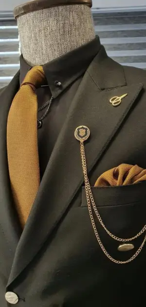 Men’s sports suit featuring a gold tie, lapel chain, and matching pocket square.
