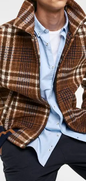 Brown plaid jacket styled with a blue shirt, showcasing modern men’s fashion.