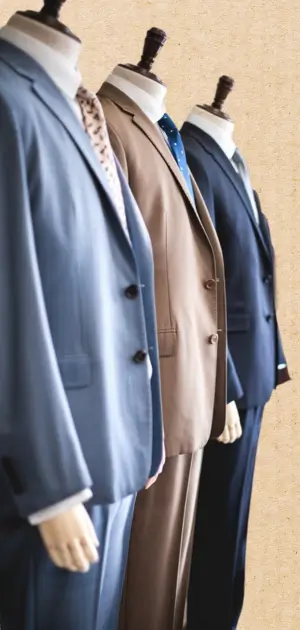 Row of men’s cotton formal suits in various colors on display and cotton suit mens sale.