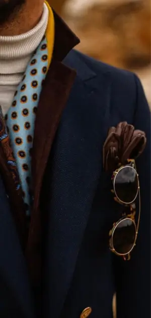 Navy vintage suit paired with a patterned scarf, sunglasses, and pocket square.