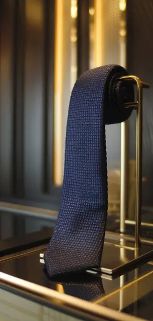 Dark blue solid tie displayed in showcase