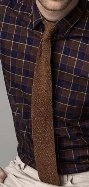 Men's dress plaid shirts a Man dressed in a sophisticated dark brown plaid shirt with a finely textured brown tie.