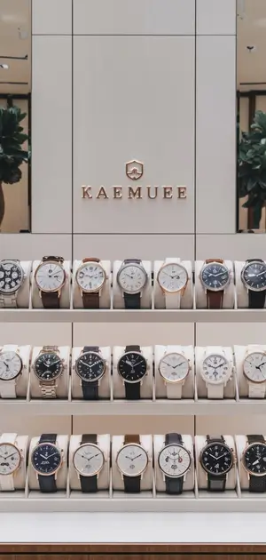 shelf filled with watches featuring white faces and various designs