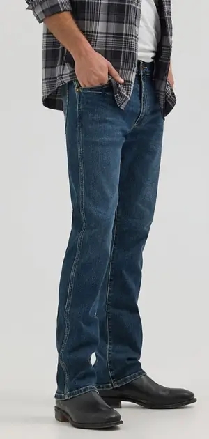 Best mens bootcut jeans Man wearing dark blue bootcut jeans paired with a plaid shirt and boots.