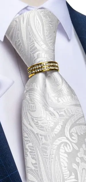 Men's white tie featuring paisley designs and a gold clip, perfect for formal wear.