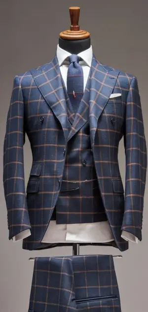 Blue herringbone suit with white shirt and tie on mannequin.