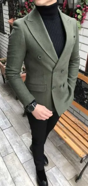 A man wearing an olive double-breasted athletic blazer with a turtleneck.