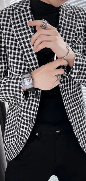 Men’s black-and-white houndstooth plaid blazer styled with bold rings and a statement watch.