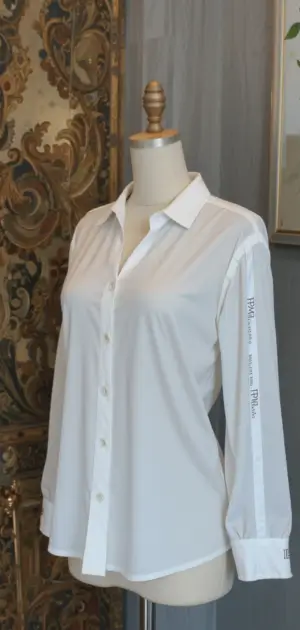 A crisp white solid women’s blouse with long sleeves and button-down detailing.