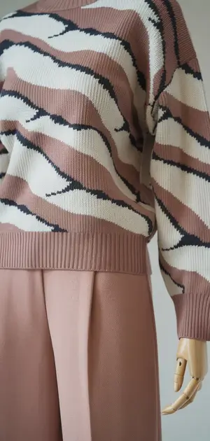 Mannequin featuring a beige polyester sweater with leafy designs