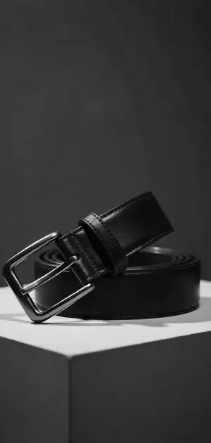 A black leather belt with a silver buckle, set on a dark background.