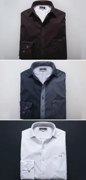 Three folded formal dress shirts in black, navy, and white on display.