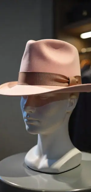 A light pink Hat with a matching ribbon on a mannequin.