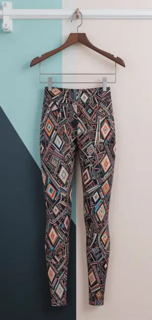 Colorful geometric-patterned leggings hanging on a wooden hanger.
