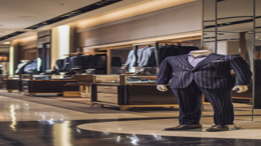 Dark pinstriped suit with matching trousers displayed under warm lighting.