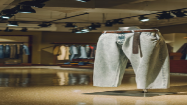 Relaxed acid-wash jeans with a brown belt in a modern store display