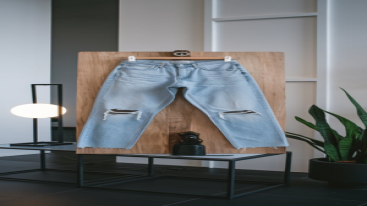 Hanging light blue jeans with a lamp and plant in the background.