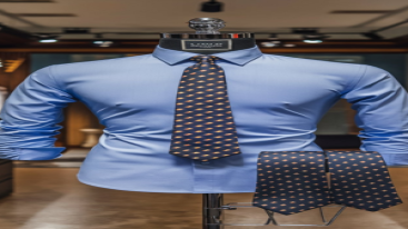 fitted blue shirt with a geometric-patterned tie displayed on a mannequin