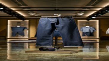 Straight-fit indigo jeans paired with a belt, displayed in a luxurious showroom.