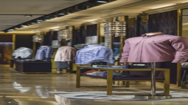 Row of mannequins displaying a variety of dress shirts in a designer store"